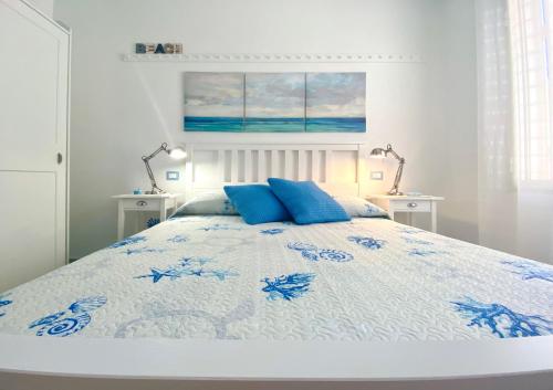 a bed with two blue pillows on top of it at Stella Marina in Santa Maria Navarrese