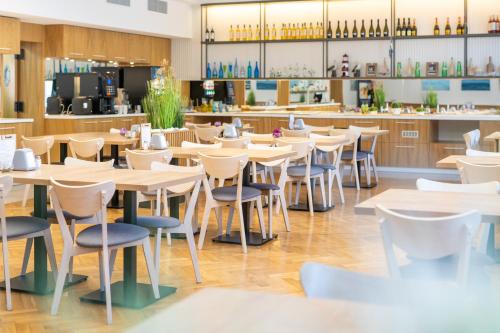 an empty restaurant with tables and chairs at SeaPark Hotel Wellness & Spa in Kołobrzeg