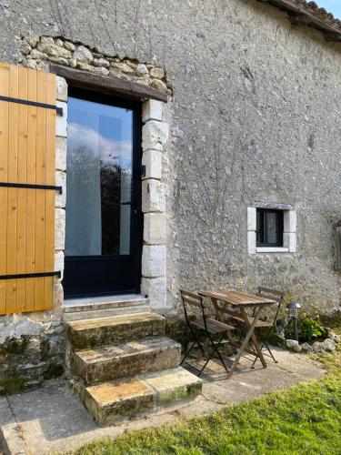 uma porta de madeira e uma mesa ao lado de um edifício em L'anne xe, studio indépendant em Valeuil