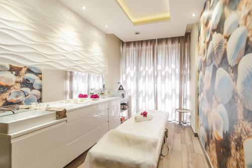 a white bathroom with a sink and a counter at SeaPark Hotel Wellness & Spa in Kołobrzeg