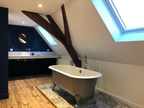a bath tub in a bathroom with a skylight at Les chambres Berguoises Superbe Chambre au coeur de Bergues in Bergues