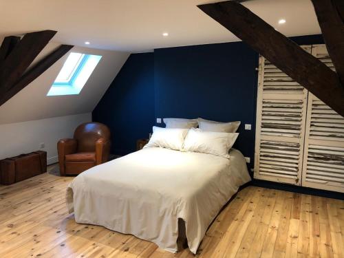 une chambre avec un grand lit et un mur bleu dans l'établissement Les chambres Berguoises Superbe Chambre au coeur de Bergues, à Bergues