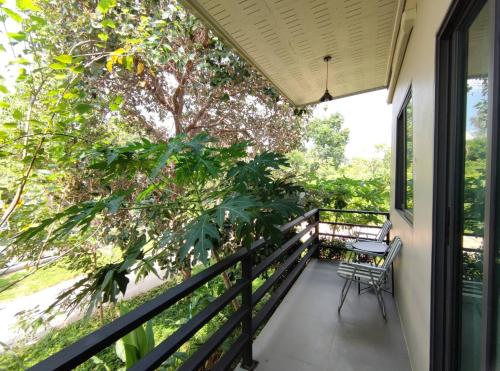 a balcony with a table and chairs on it at Morinaka Craftfe & Poshtel in Ban Na Muang