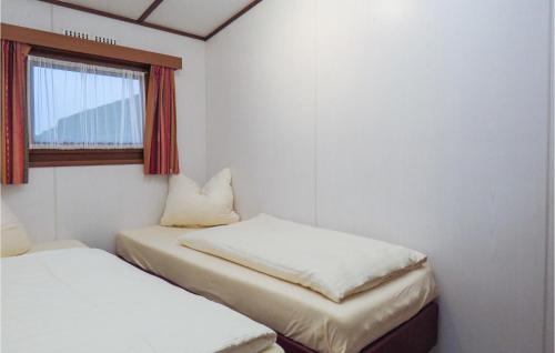een kleine kamer met 2 bedden en een raam bij Nice Home In Gerolstein With 2 Bedrooms And Wifi in Gerolstein