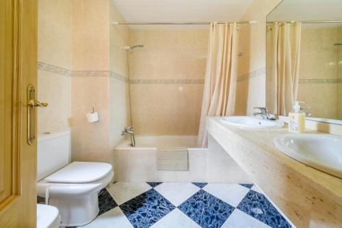 a bathroom with a toilet and a sink and a tub at Casa Campillos in Llucmajor