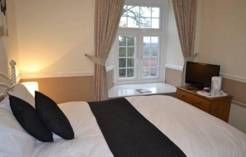 1 dormitorio con cama, ventana y TV en Brewers Lodge, en Blackwood