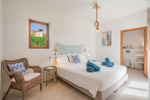 a bedroom with a large bed and a chair at Casa Puro in Cala Llombards