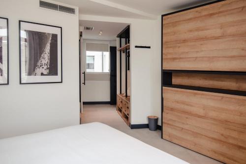 a bedroom with a bed and a wooden closet at LATROUPE La Granja in Bilbao