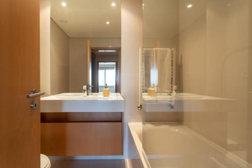 a bathroom with a sink and a tub and a mirror at Casa da Cidade in Vila Nova de Gaia