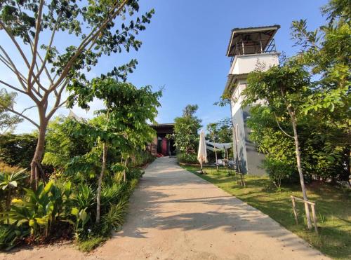 a path leading up to a house with trees at Morinaka Craftfe & Poshtel in Ban Na Muang