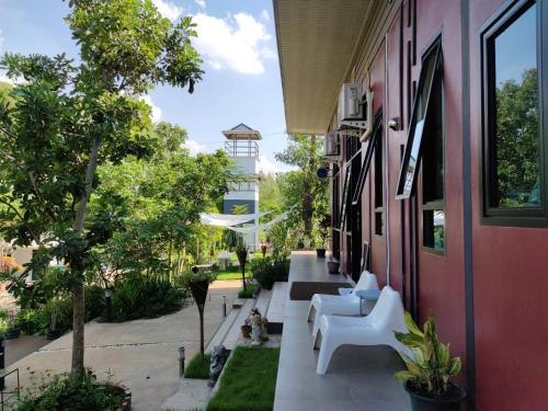 a building with white benches on the side of it at Morinaka Craftfe & Poshtel in Ban Na Muang