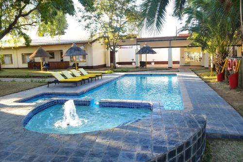 a swimming pool with a fountain in a yard at Cresta Botsalo Hotel in Palatswe