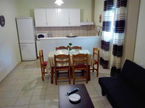 a kitchen and dining room with a table and chairs at Katerina's home in Moraitika