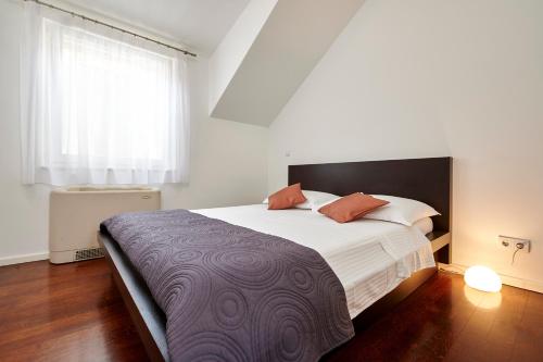 a bedroom with a large bed and a window at Apartments Gea Trogir in Trogir