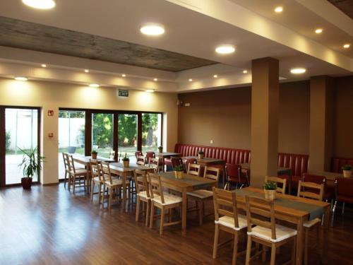 a dining room with wooden tables and chairs at Garden Club Panzió in Balatonmáriafürdő