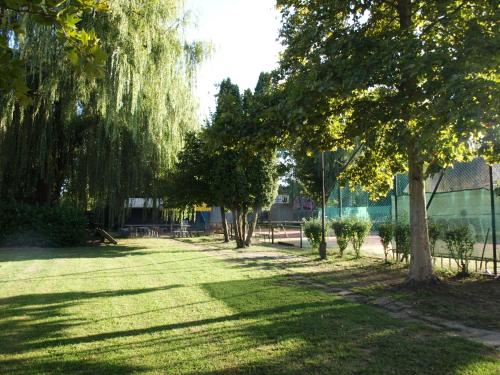 a park with trees and grass and a fence at Garden Club Panzió in Balatonmáriafürdő
