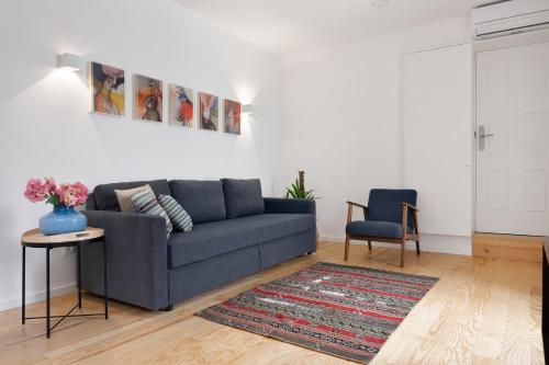 a living room with a blue couch and a rug at Oporto Classic Terrace in Porto