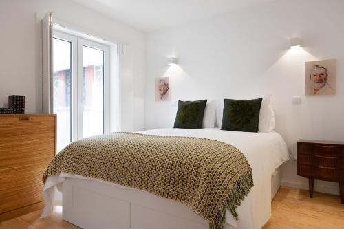 a white bedroom with a bed and a window at Oporto Classic Terrace in Porto