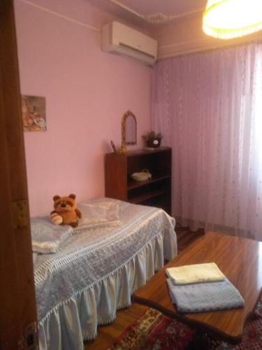 um urso de peluche sentado numa cama num quarto em Guest House Armina em Yerevan