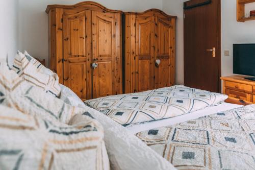een slaapkamer met een bed en een houten kast bij Feriendomizil-Sauerland FeWo 3 in Medebach