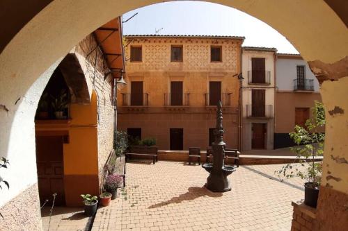 un arco que conduce a un patio con un edificio en Casa Xavier - Apartamento 1, en Àger