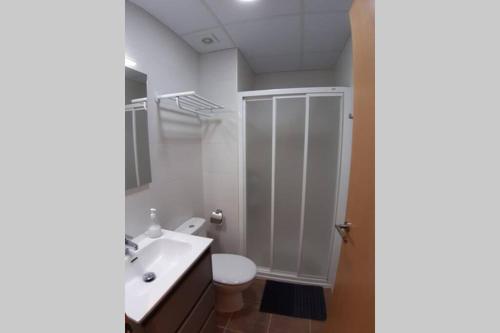 a white bathroom with a toilet and a sink at Casa Xavier - Apartamento 1 in Ager