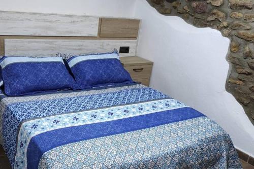 een slaapkamer met een bed met blauwe en witte lakens en kussens bij Casa Xavier - Apartamento 1 in Ager