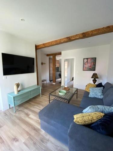 sala de estar con 2 sofás azules y TV de pantalla plana en Apartamentos Cañalío, en Santander