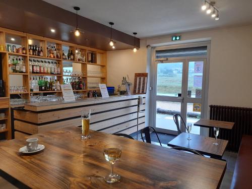 un restaurant avec une table en bois et un bar dans l'établissement Au Moulin Du Pont, à Samognat