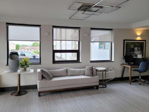 a living room with a couch and some windows at Comfort Inn & Suites Wyomissing-Reading in Wyomissing