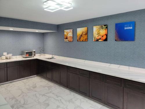 a kitchen with four paintings on the wall at Comfort Inn & Suites Wyomissing-Reading in Wyomissing