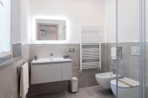 ein Badezimmer mit einem Waschbecken, einem WC und einem Spiegel in der Unterkunft Versilia Residence - Colombo in Lido di Camaiore