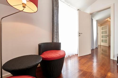 a living room with two chairs and a red stool at Apartments Gea Trogir in Trogir