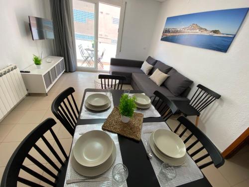 a dining table and chairs in a living room at Apartamentos AR Isern in Blanes