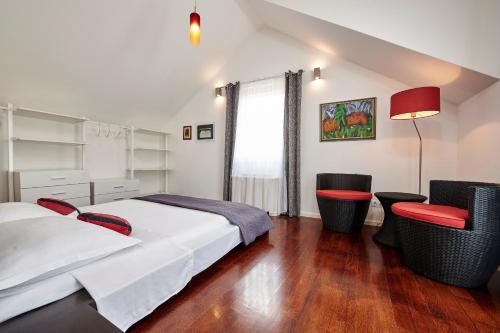 a hotel room with two beds and two chairs at Apartments Gea Trogir in Trogir