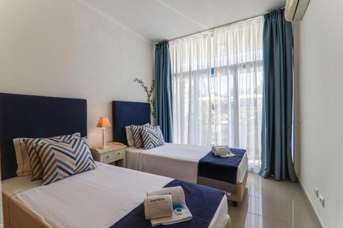 een hotelkamer met 2 bedden en een raam bij Apartamento Millennium in Vilamoura