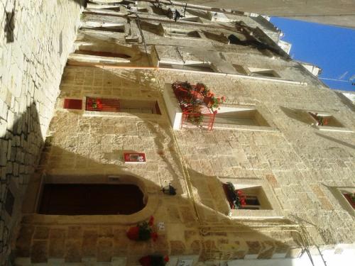 a building with red flowers on the side of it at B&B Borgo San Martino in Monopoli