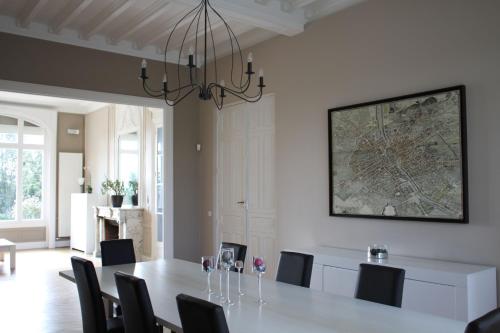 a dining room with a table with chairs and a map on the wall at Château de la Folie in Trie-Château