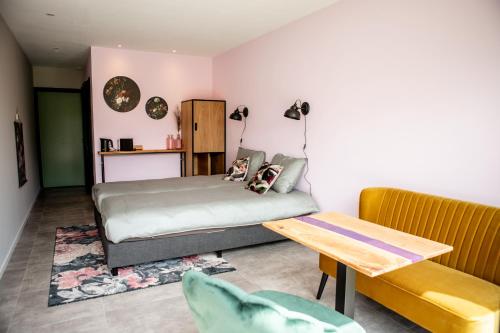 1 dormitorio con 1 cama y 1 mesa en Natuur lodge en Blesdijke