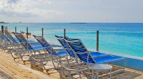 a row of blue chairs sitting on the beach at Deluxe Sea View Villas at Paradise Island Beach Club Resort in Creek Village