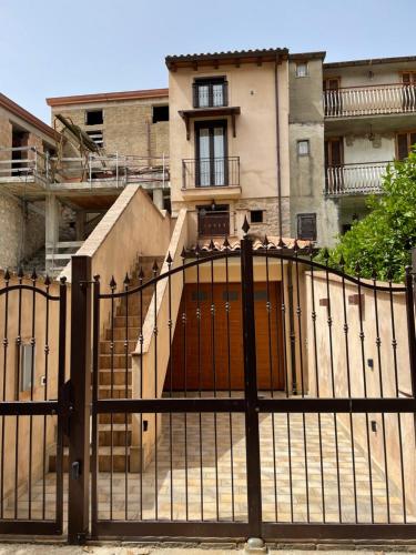 a gate in front of a house with a building at La Vie En Rose in Fondi