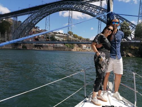 two people standing on a boat in front of a bridge at Douro Captain in Vila Nova de Gaia
