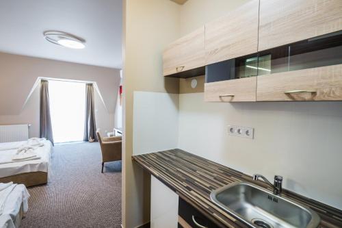 a kitchen with a sink and a bed in a room at Beach Magánszálláshely in Siófok