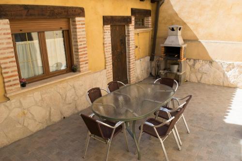 a glass table and chairs in a room with a stove at Vivienda Turistica El Caneco in Tordesillas