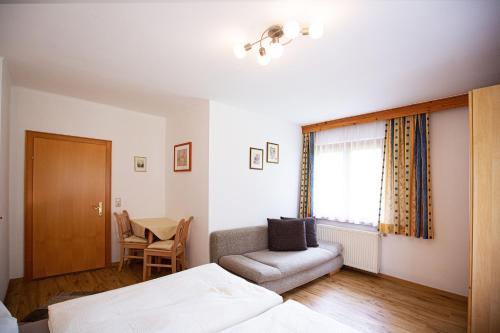 a bedroom with a bed and a chair and a table at Ferienhaus Nationalpark in Neukirchen am Großvenediger
