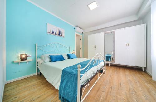 een slaapkamer met een bed met blauwe muren en houten vloeren bij El Lavandee in Varenna