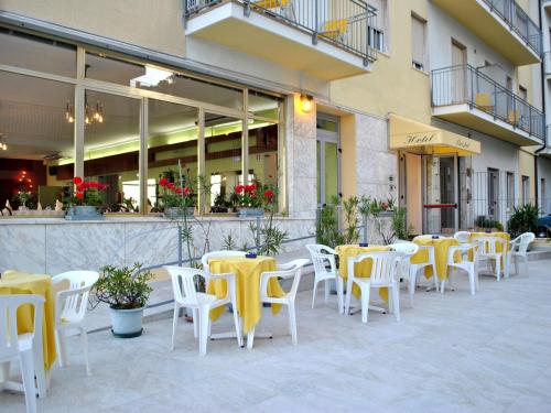 a group of tables and chairs in front of a building at Hotel Bristol in Laigueglia