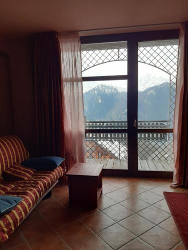 a room with a couch and a window with a view at Prato Nevoso Borgo Stalle Lunghe con accesso diretto alle piste da sci in Prato Nevoso