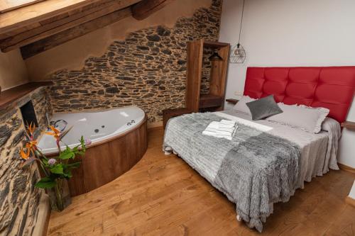 a bedroom with a large bed and a bath tub at Apartamentos Rurales Casa Llongo in Coaña