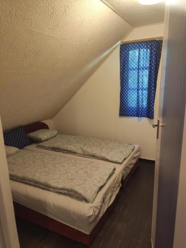 a bedroom with two beds and a blue window at Silver Beach Apartman in Vásárosnamény